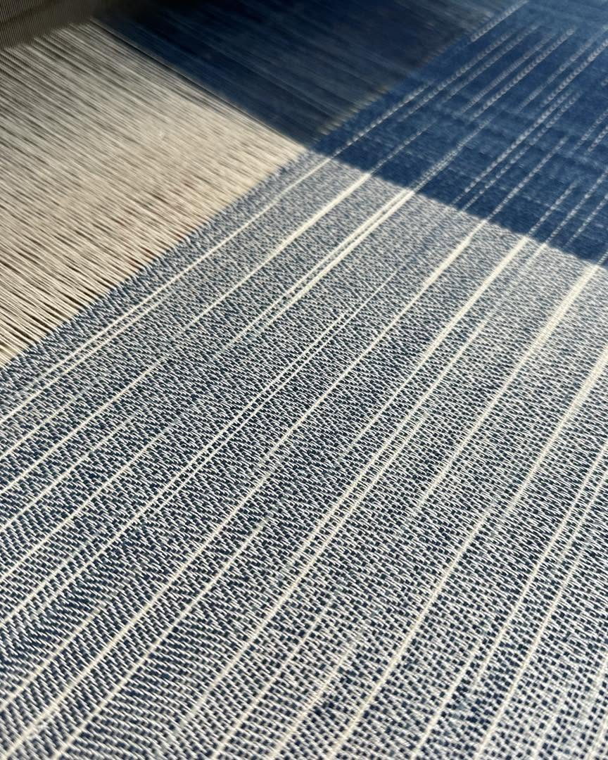 A close view of handwoven cloth striped in natural indigo
