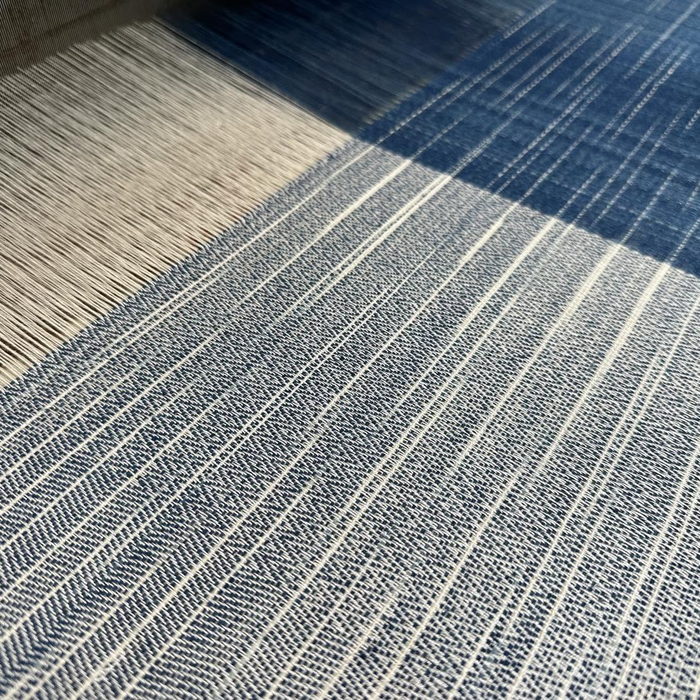 A close view of handwoven cloth striped in natural indigo