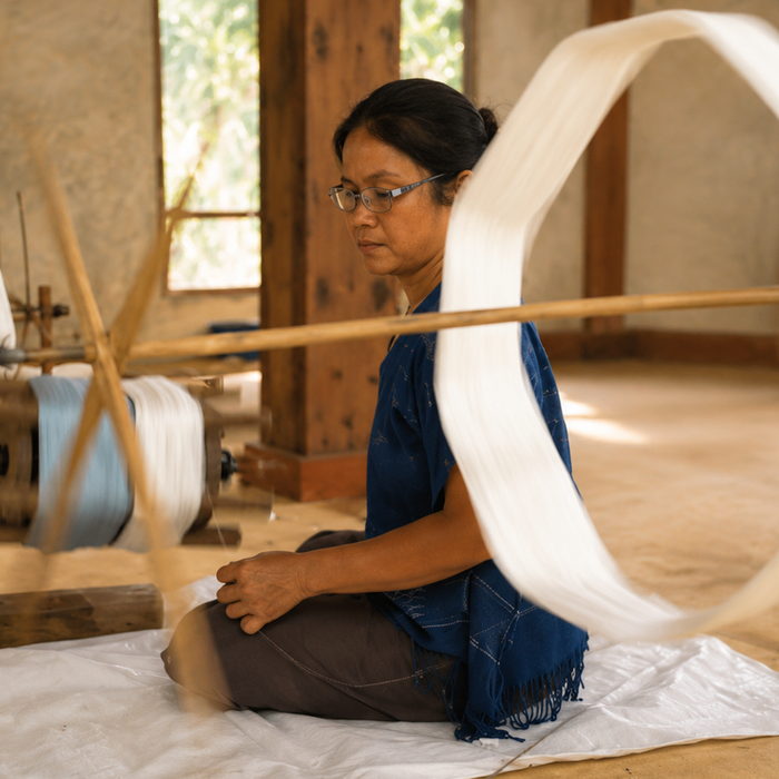 A maker winding spun cotton thread onto a skein winder